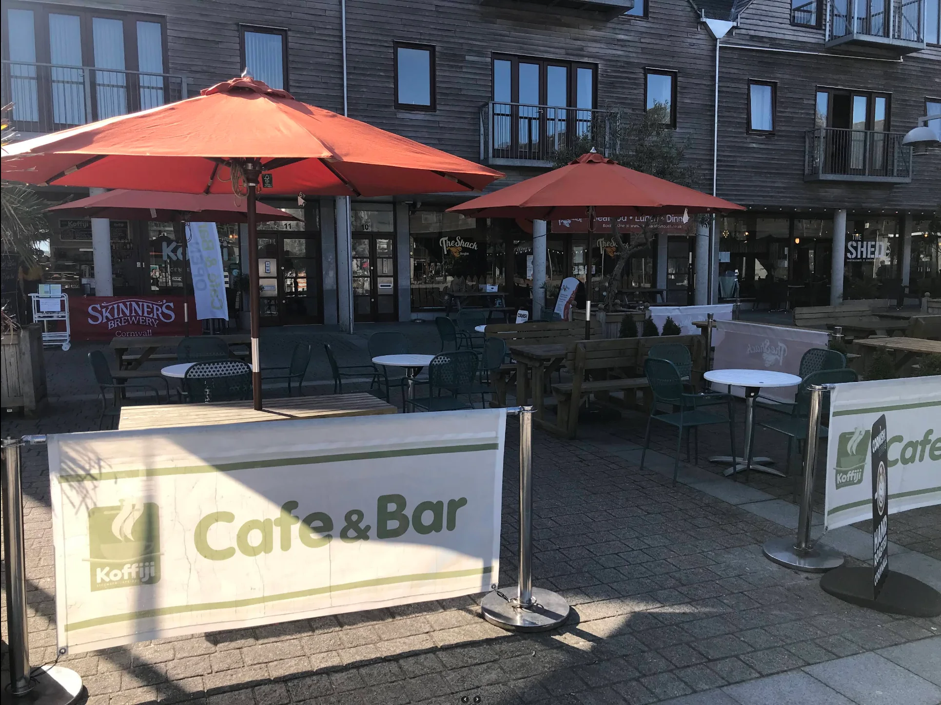 Outdoor terrace tables beneath red parasols